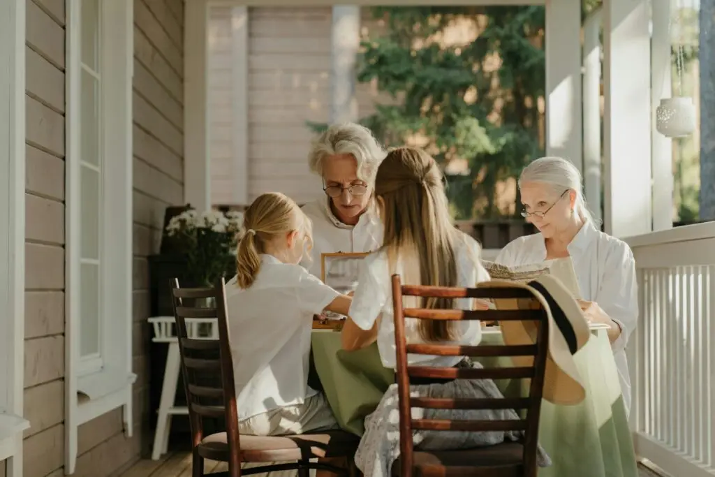 Multi-generational family sharing a moment on a sunlit veranda, capturing togetherness.