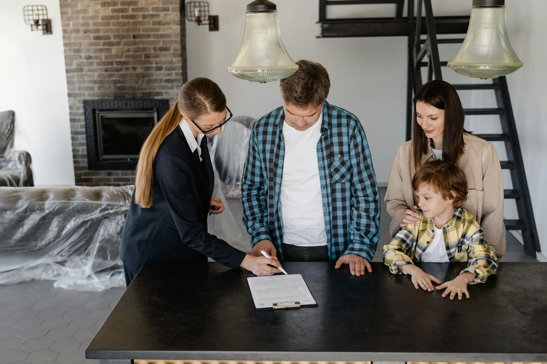 Compare Indexed Universal Life Insurance Happy family signing a real estate contract with agent inside their new home.