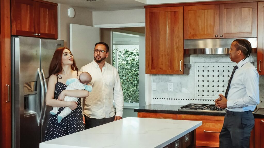 Mortgage Protection Couple with baby exploring a kitchen with a real estate agent.
