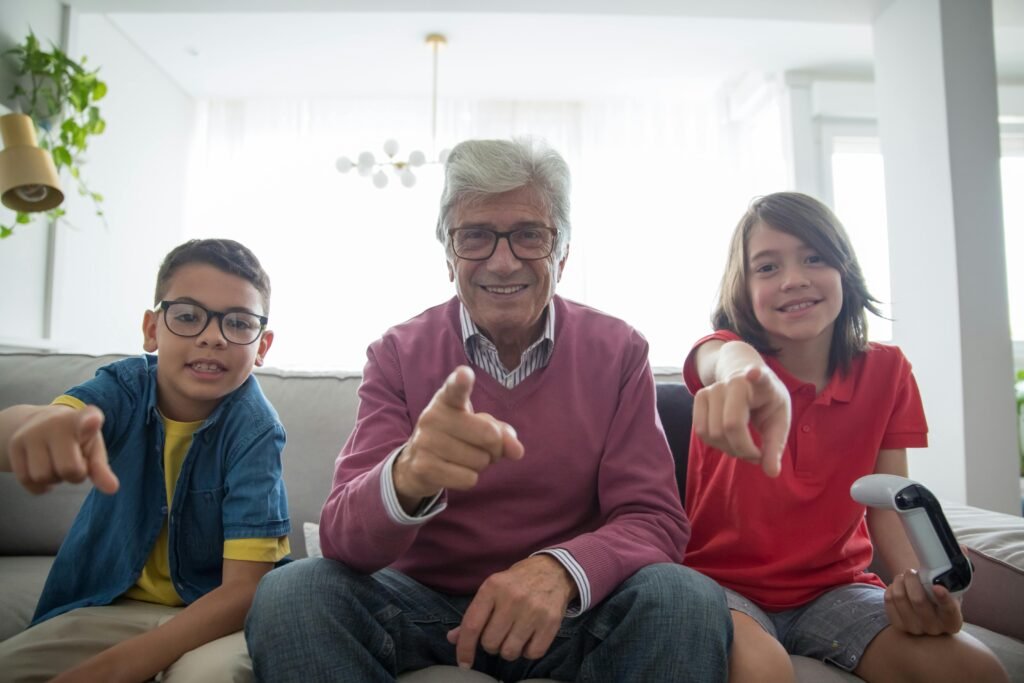 A joyful moment between a grandfather and his grandchildren playing indoors, emphasizing family bonding.