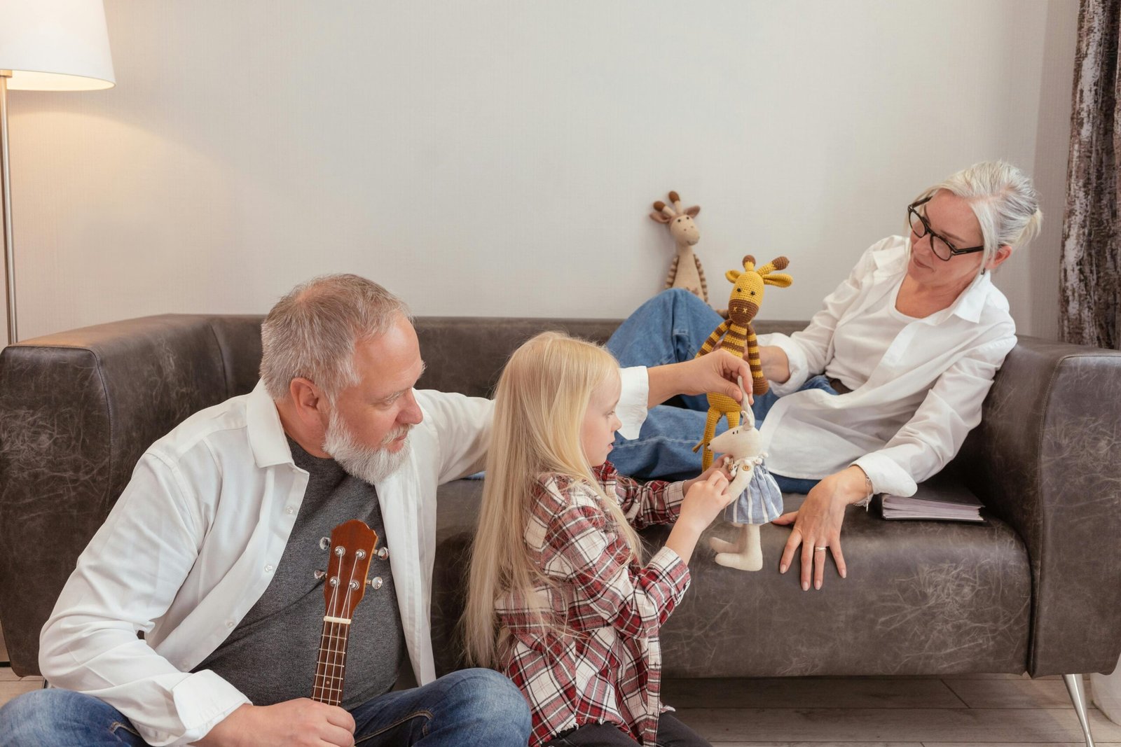 Grandparents enjoying quality time with their grandchild, playing with toys in a cozy living room.